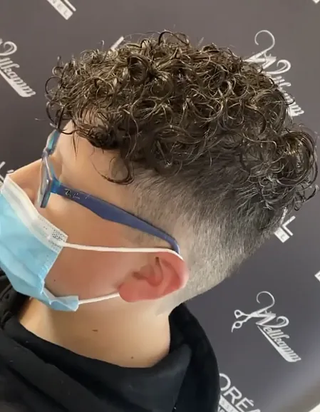 Seitliches Bild eines männlichen Kopfes mit Locken.